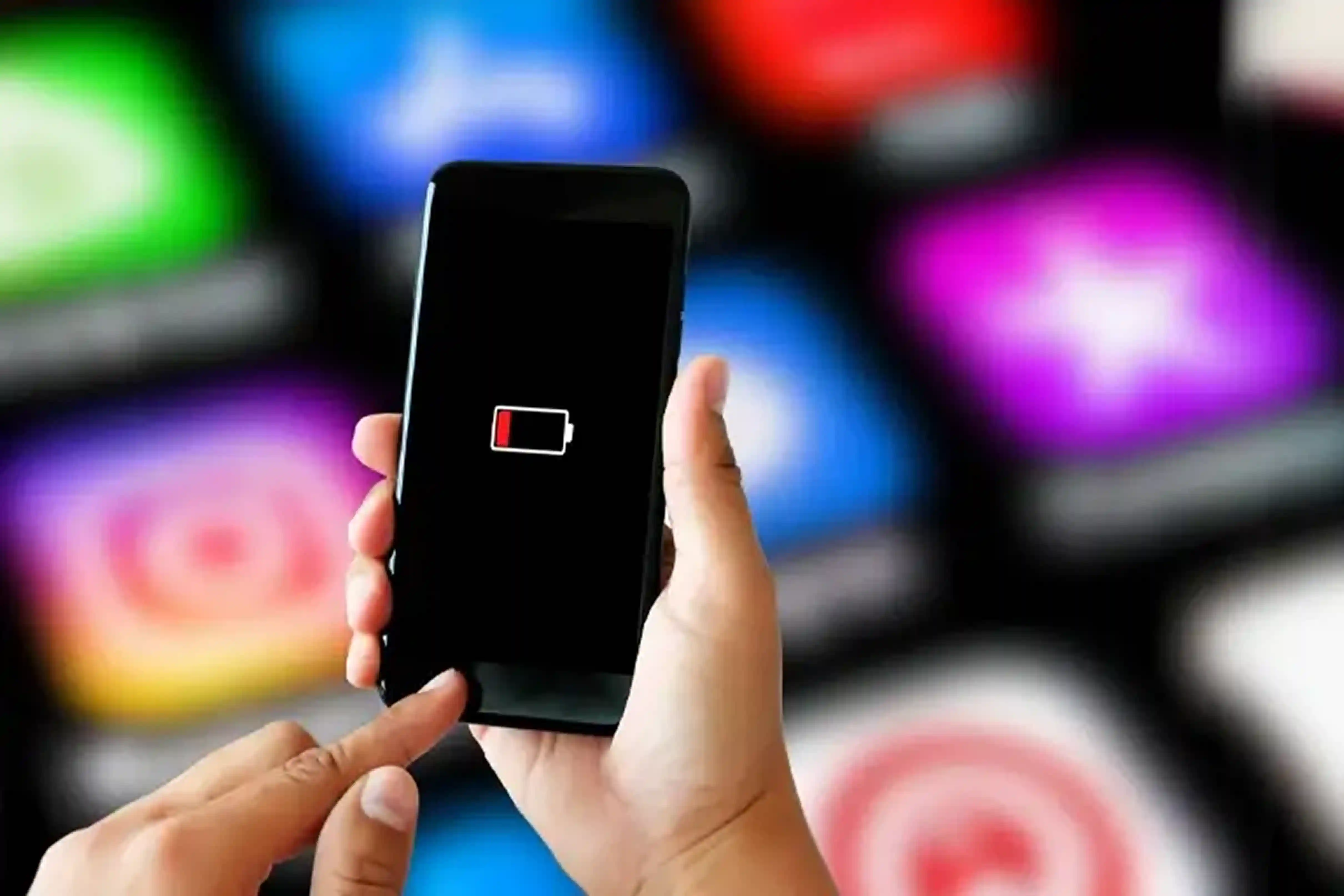 Smartphone displaying a low battery warning while being held for repair